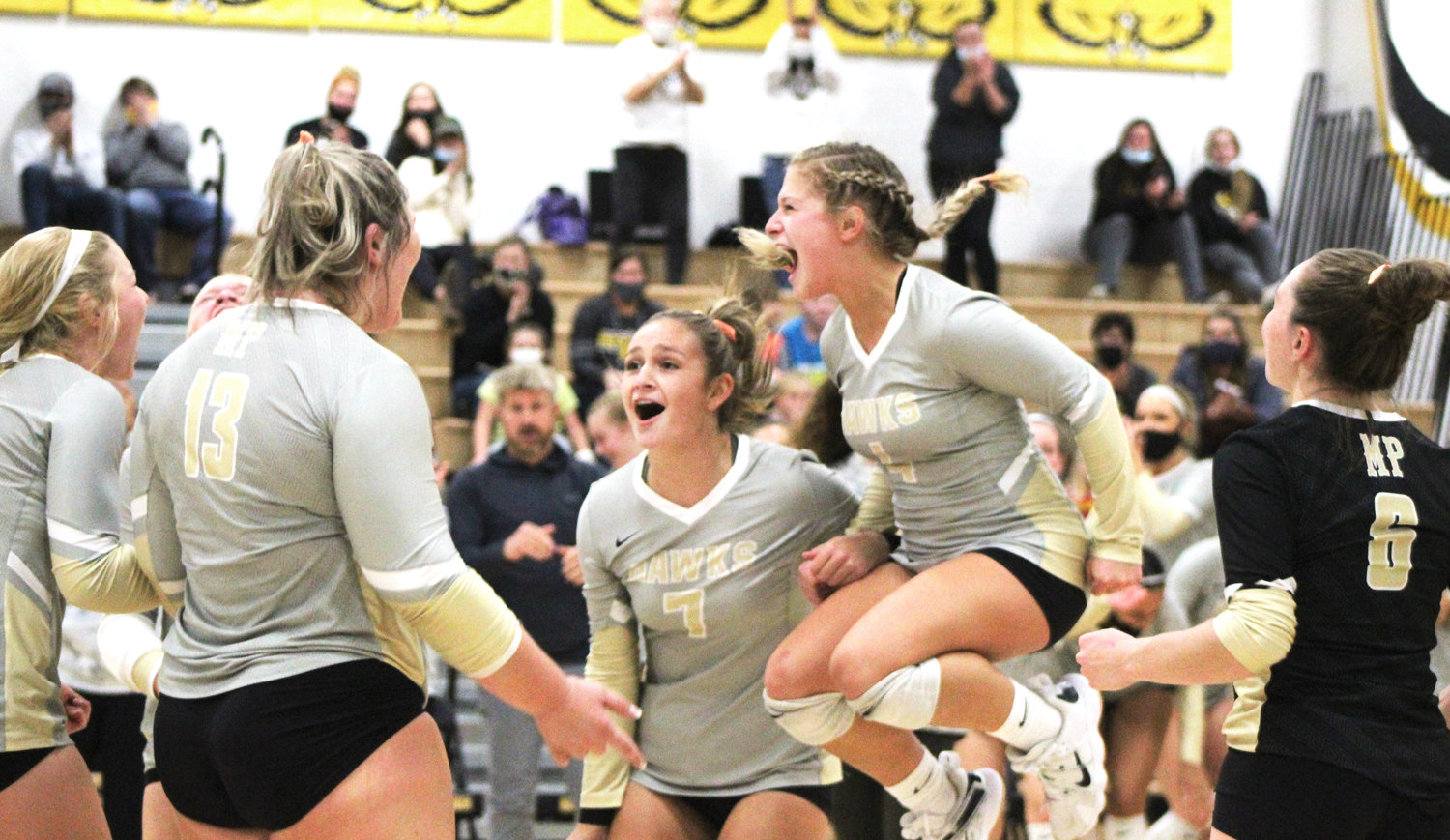 Members of the Mid-Prairie volleyball team, including seniors Maddie Edgington (right), Paige Peiffer (7), Tori Boyse (13) and Phelan Hostetler (left), celebrate their River Valley Tournament win over Tipton.