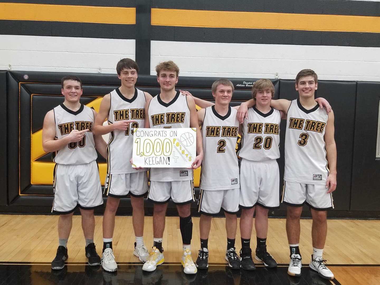 The Lone Tree seniors help Keegan Edwards celebrate his 1000th-career point Friday night against Belle Plaine.