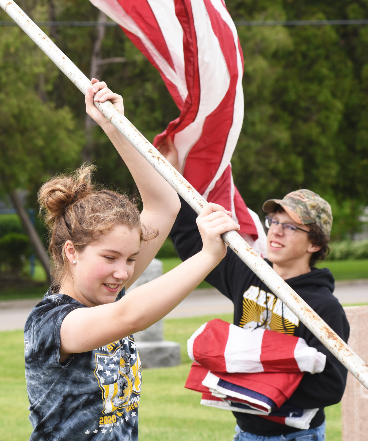 Helpers raise the flags at Sharon Hill Cemetery in Kalona.