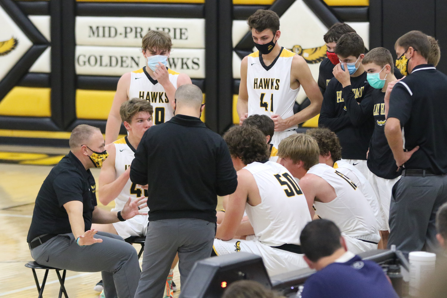 Mid-Prairie coach Daren Lambert (left) addresses his squad after the first quarter of a scrimmage with Mediapolis in Wellman on Saturday, November 21.