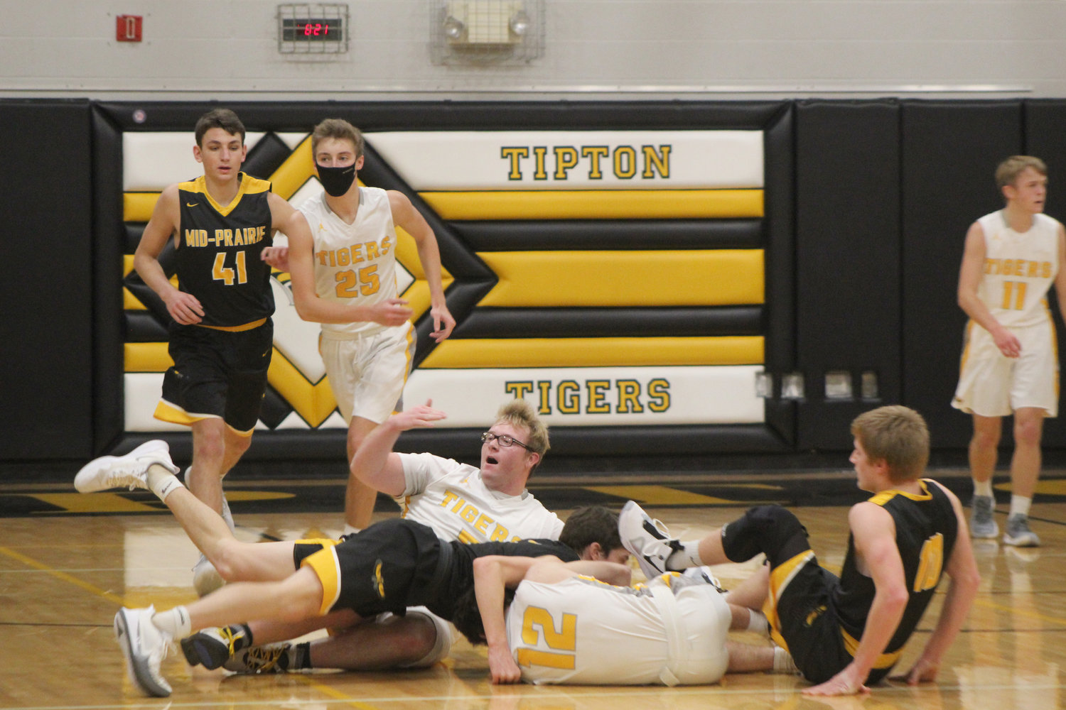 Mid-Prairie’s Will Cavanagh dives into a pile with teammate Alex Bean, right, during a chase for the basketball during last Friday’s River Valley Conference game against Tipton. The Golden Hawks shut out the Tigers for nearly the entire first quarter and won, 52-25.