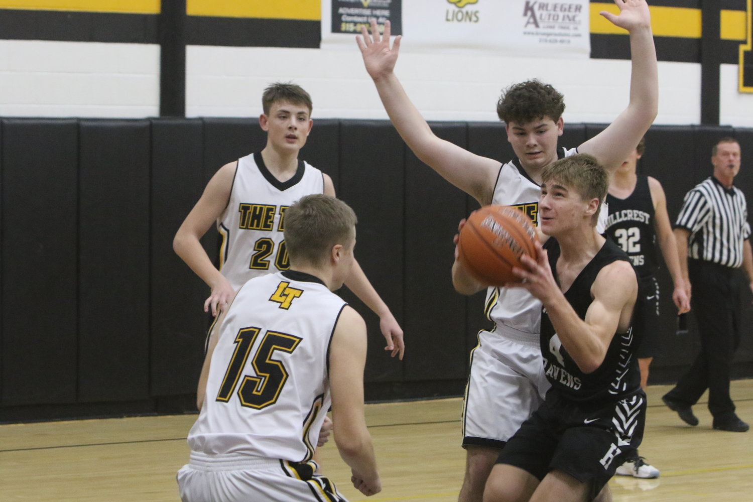 Hillcrest Academy's Luke Schrock splits the Lone Tree defense on his way toward the basket.