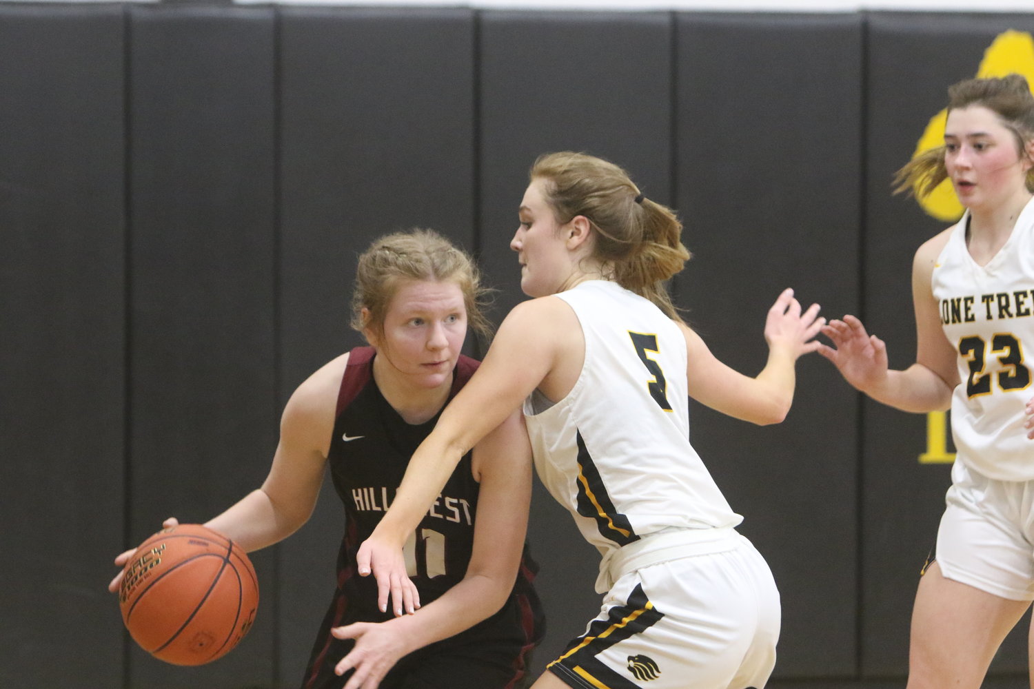 Hillcrest Academy senior Esther Hughes moves the ball against Lone Tree's Rylee Shield. Hughes had 17 points and a game-high 12 rebounds for a double-double.