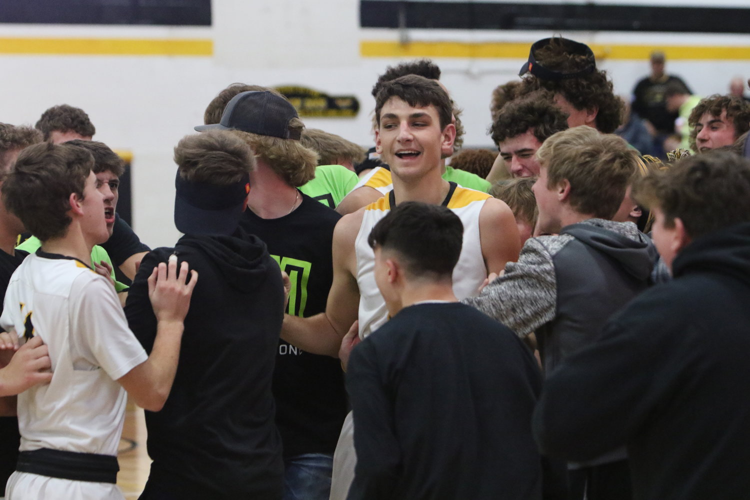 Golden Hawk students and fans surround Mid-Prairie senior center Ethan Kos after Monday's victory over Williamsburg.