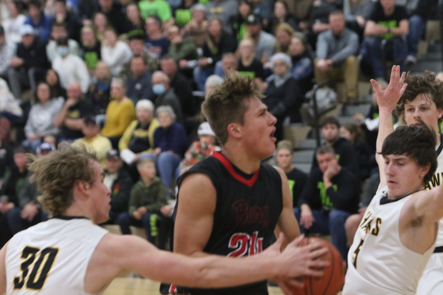 Williamsburg sophomore forward Derek Weisskopf charges toward the hoop against Mid-Prairie's Will Cavanagh, but he was called for an offensive foul.