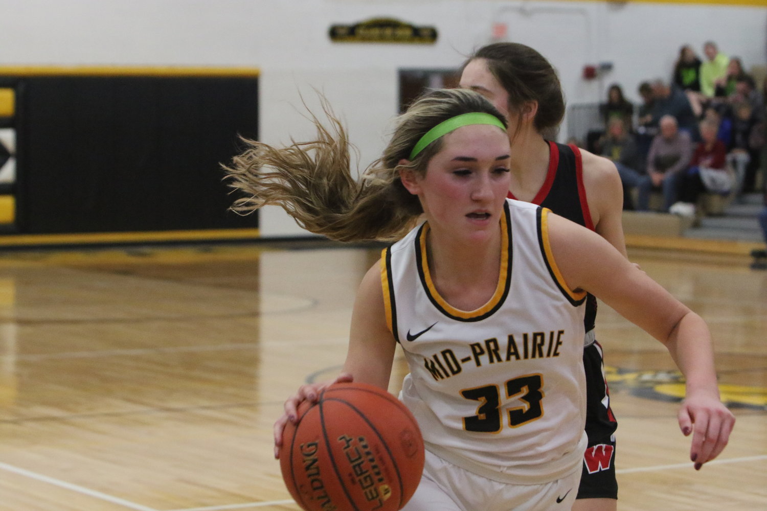 Mid-Prairie senior forward Maddie Nonnenmann dribbles past a Williamsburg defender in Monday's girls basketball game.