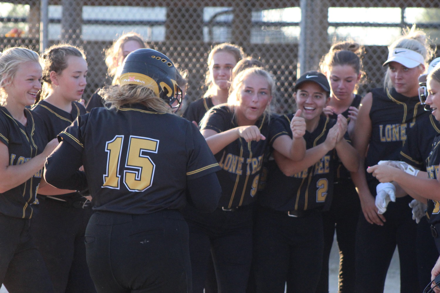 Lone Tree senior Kinley Hayes is greeted by her teammates at home plate after hitting a home run in Friday's game against New London.