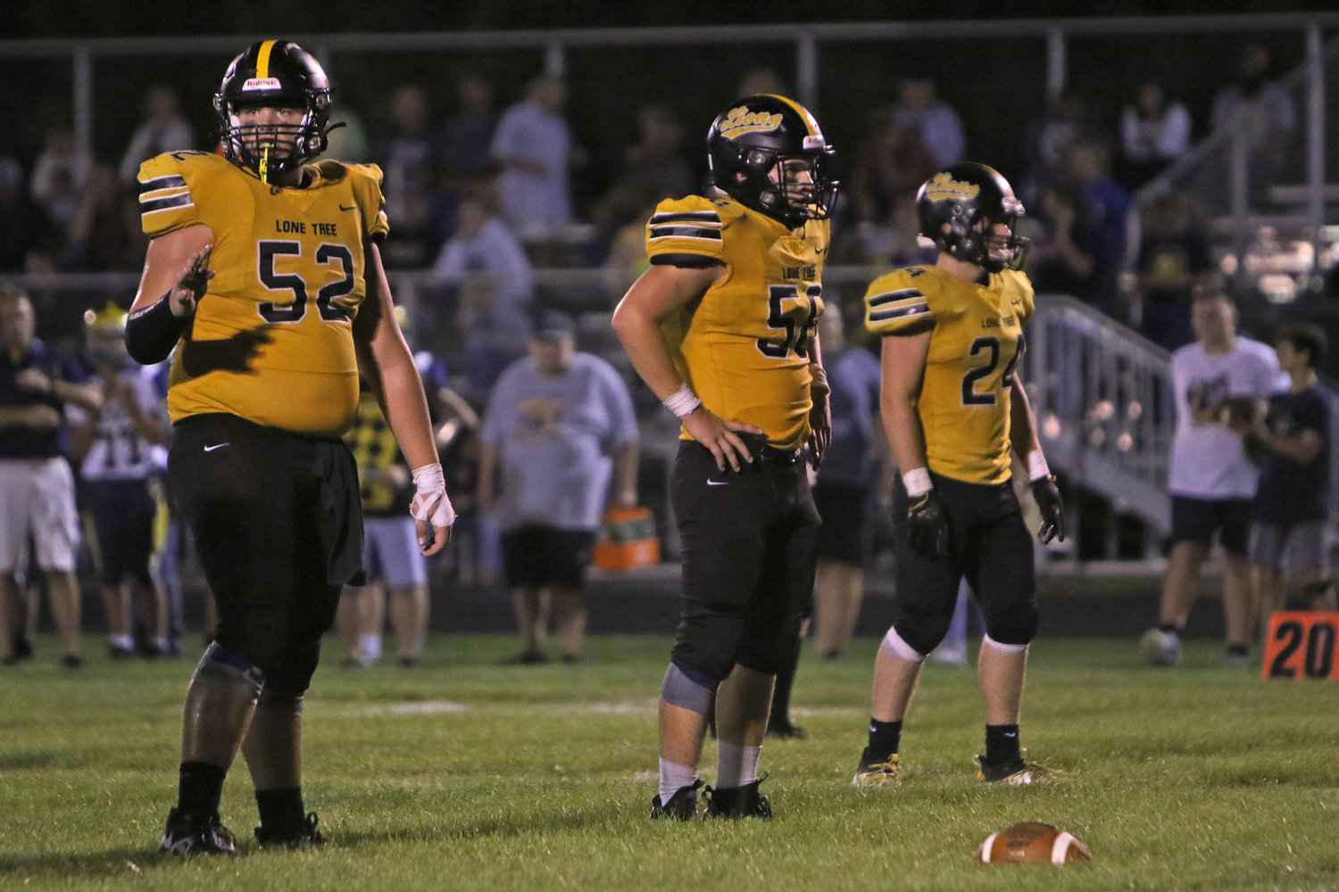 The Lone Tree defensive line of Mitch Koedam, Andrew Hotz, and Joe Boxwell waits for the next snap.