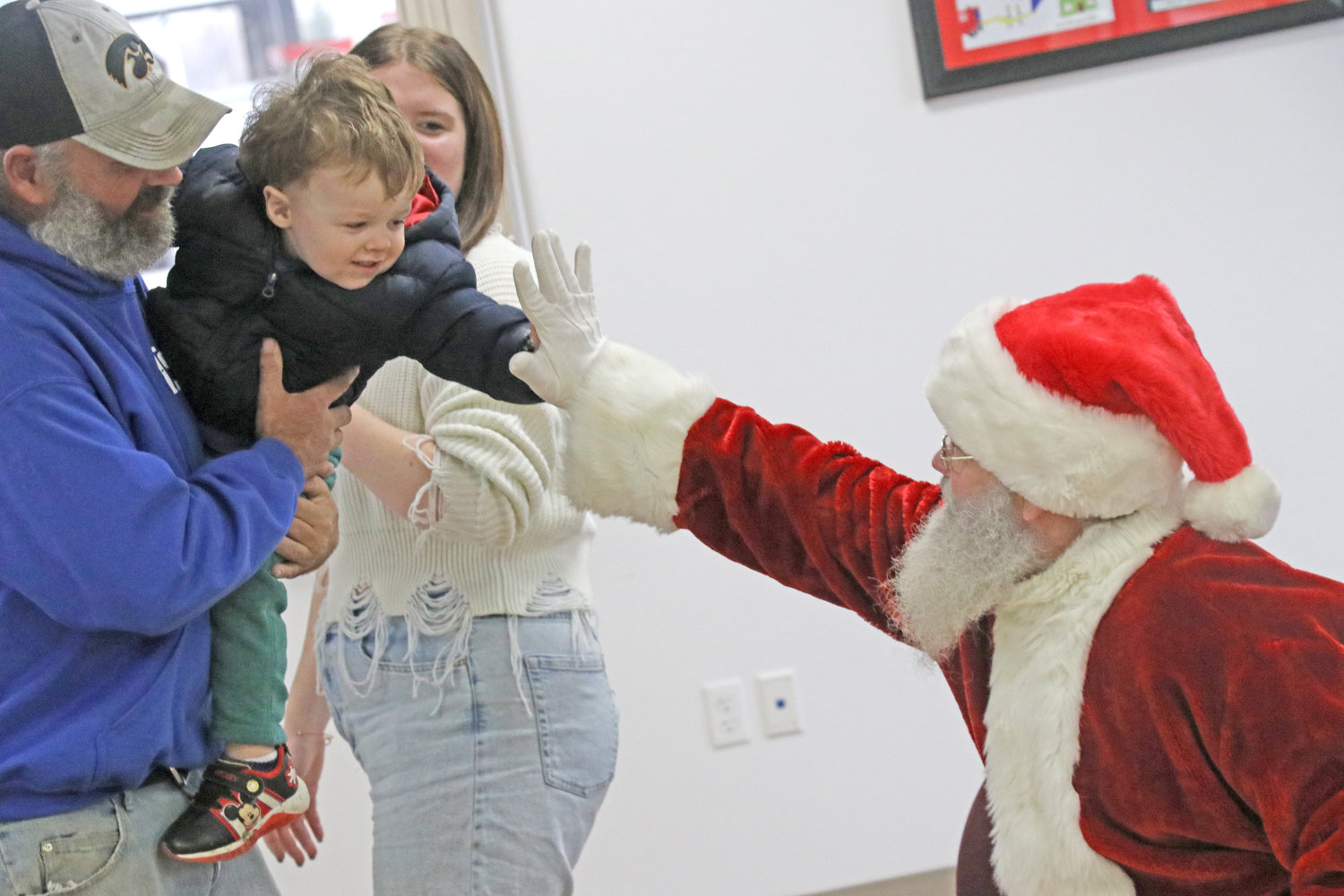 A high-five seals the deal: Santa is going to come through for this little guy.