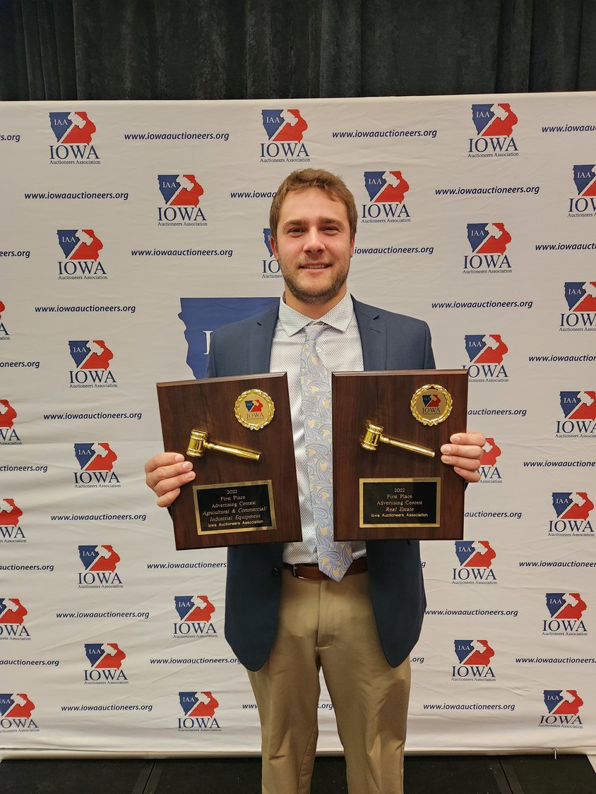 Riley Sieren with the two First Place awards won by Sieren Auction Sales at the Iowa Auctioneers Annual Convention.