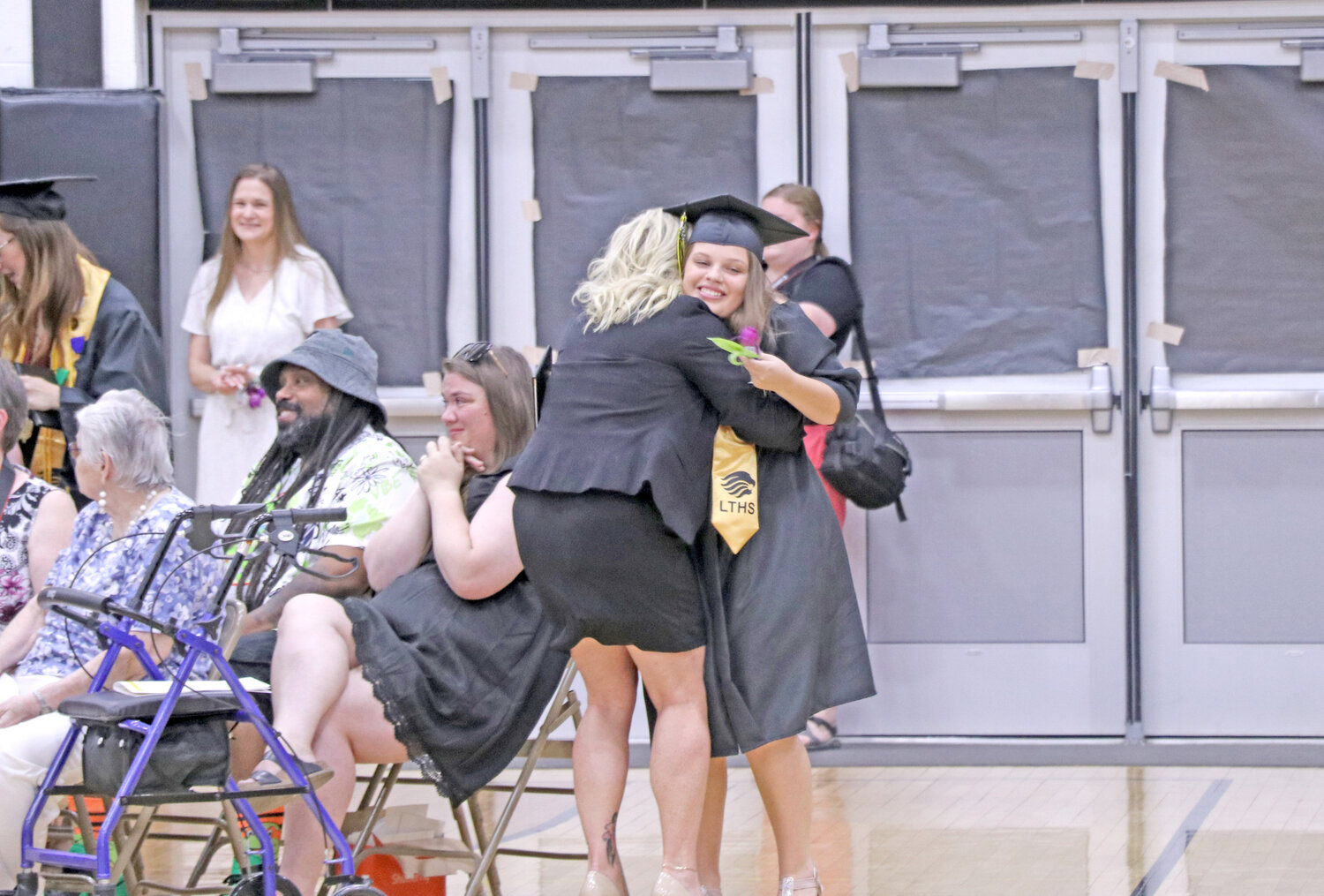 Lone Tree graduate Jenna Dotson is embraced after walking the stage and receiving her diploma.