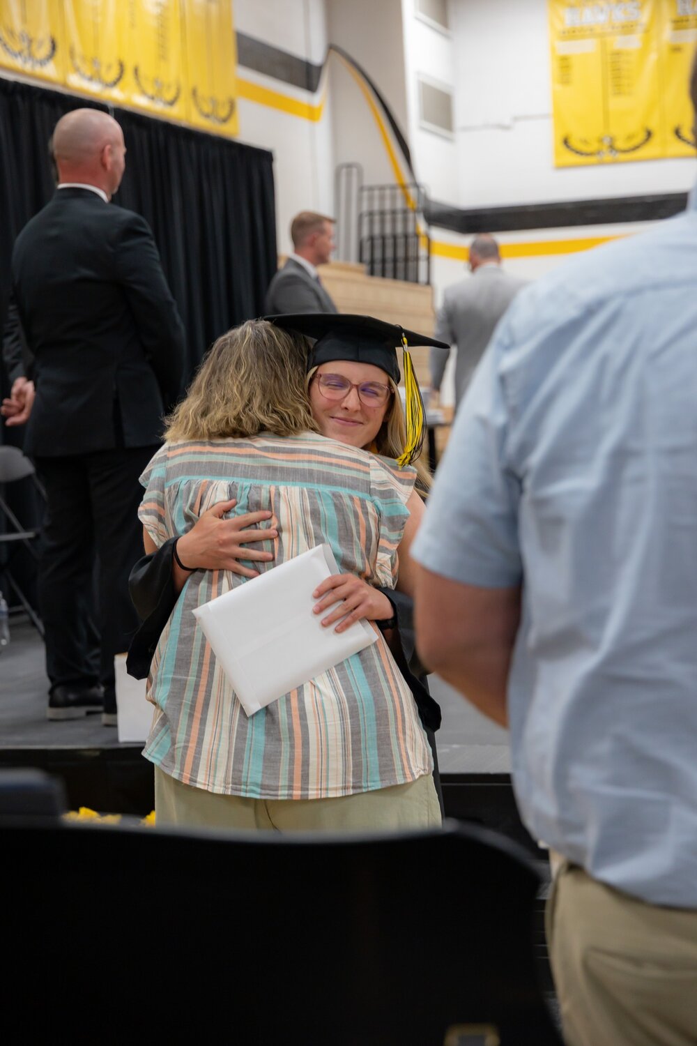 Valedictorian Amara Jones hugs Elsa Schmidt after receiving her diploma.