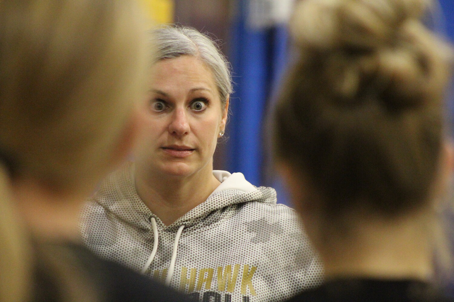 The stare of Mid-Prairie head volleyball coach Sherry Evans gets the attention of the Golden Hawks in a team huddle.