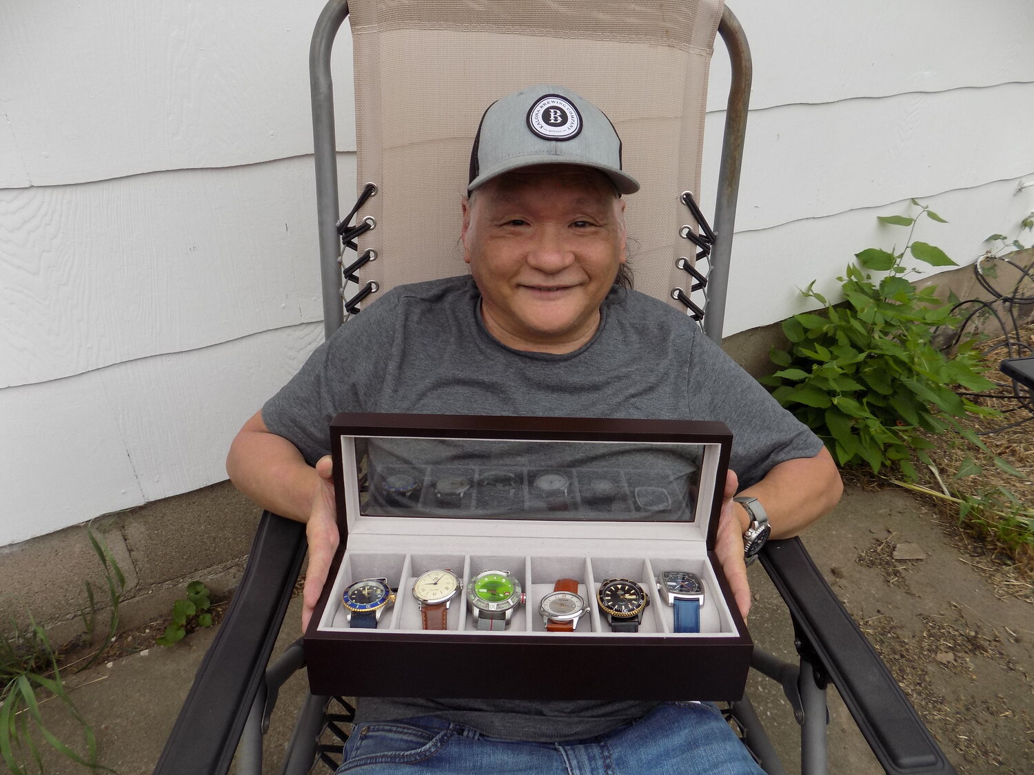 Glen Mayeno with a few of his favorite watches, outside his home in Wellman.