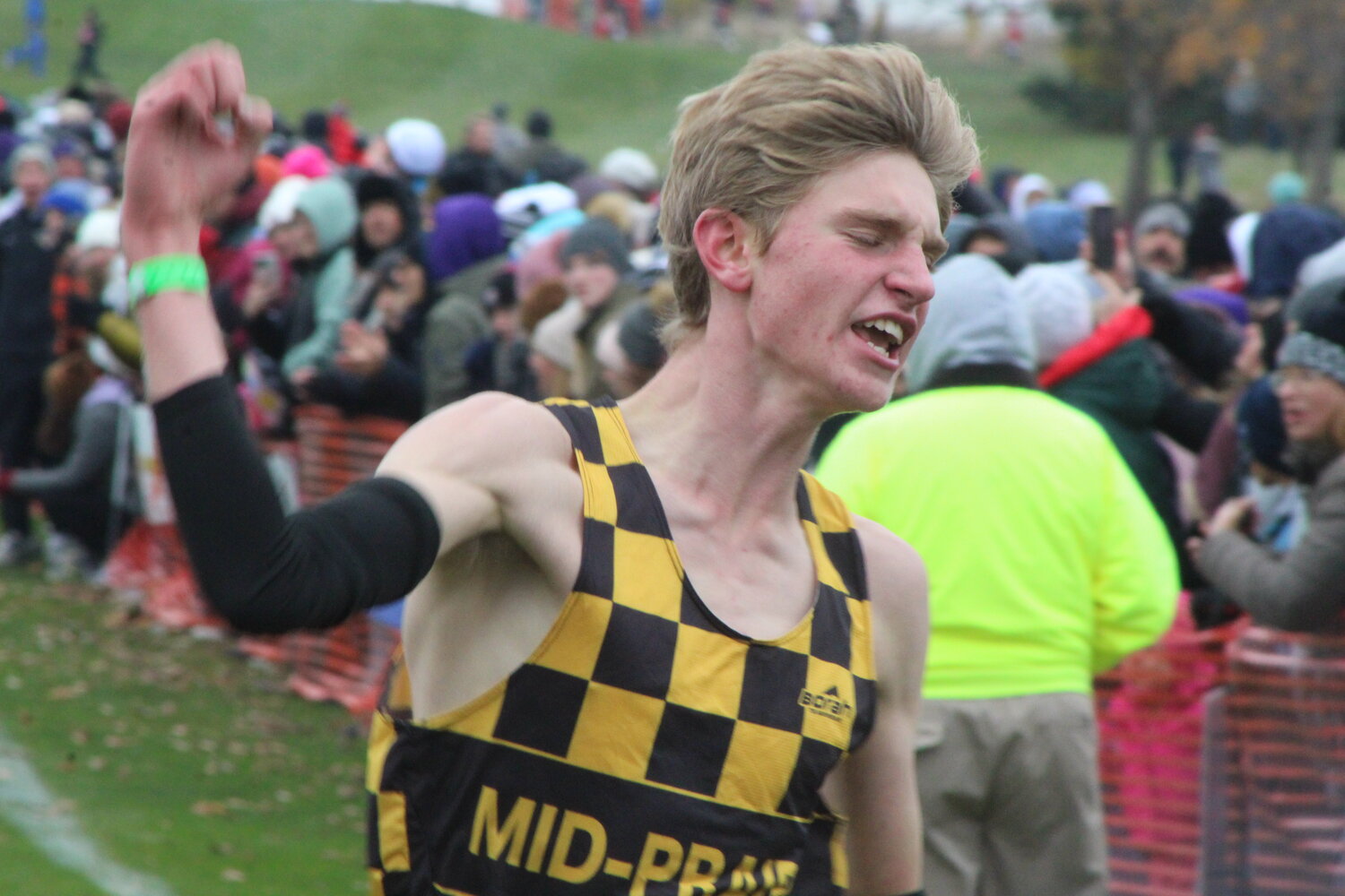 Emmett Swartzentruber of Mid-Prairie celebrates as he crosses the finish line for the first boys individual state championship in Golden Hawks history.