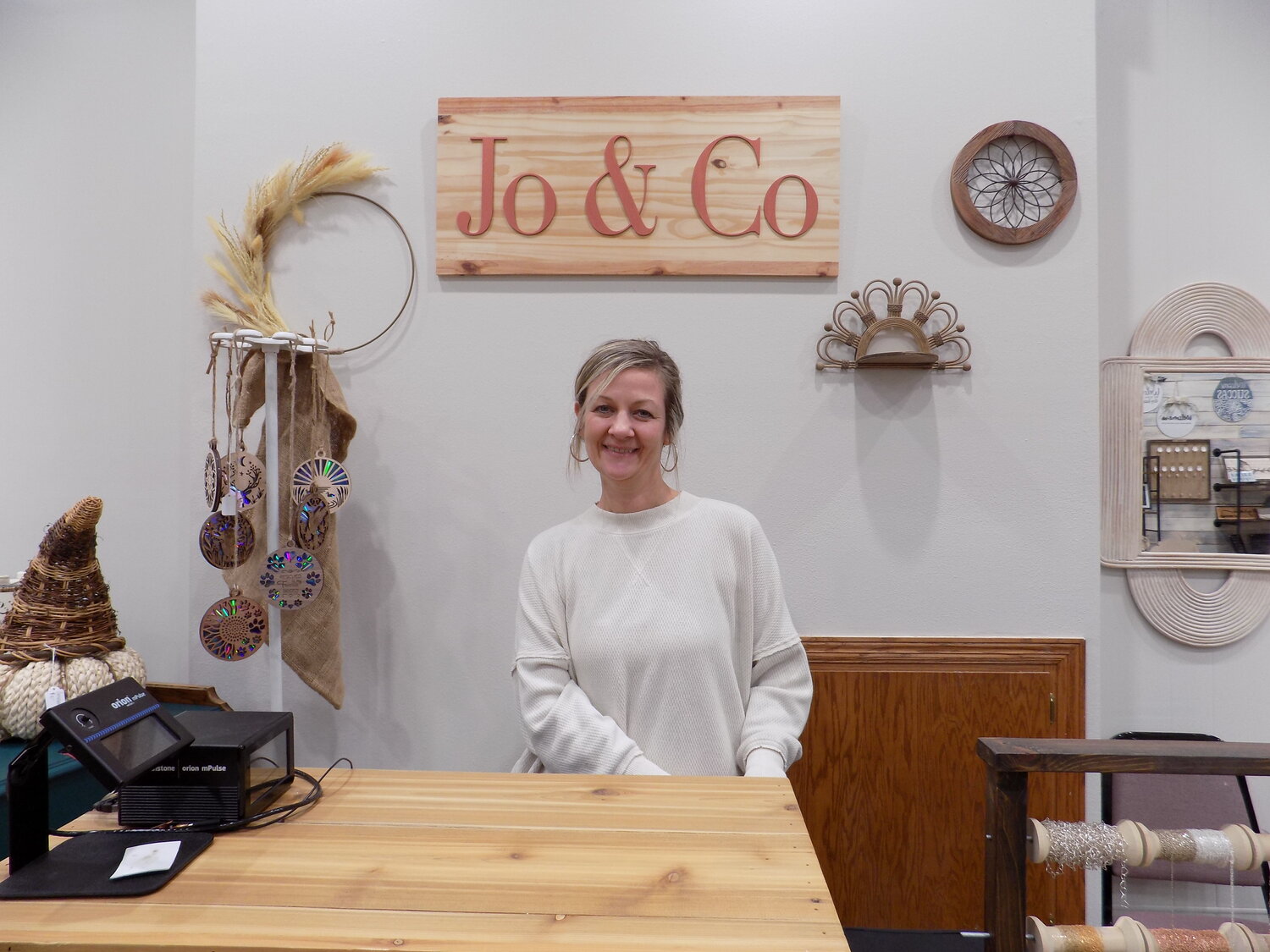 Melissa Rediger behind the cashwrap and permanent jewelry counter at her shop, Jo & Co, in downtown Wellman.
