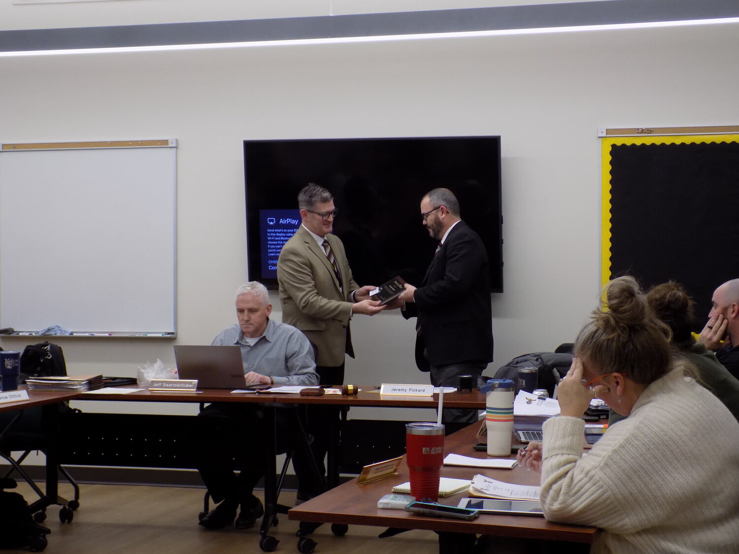 Superintendent Brian Stone, left, presents retiring board president Jeremy Pickard with a plaque commemorating his 14 years of service.
