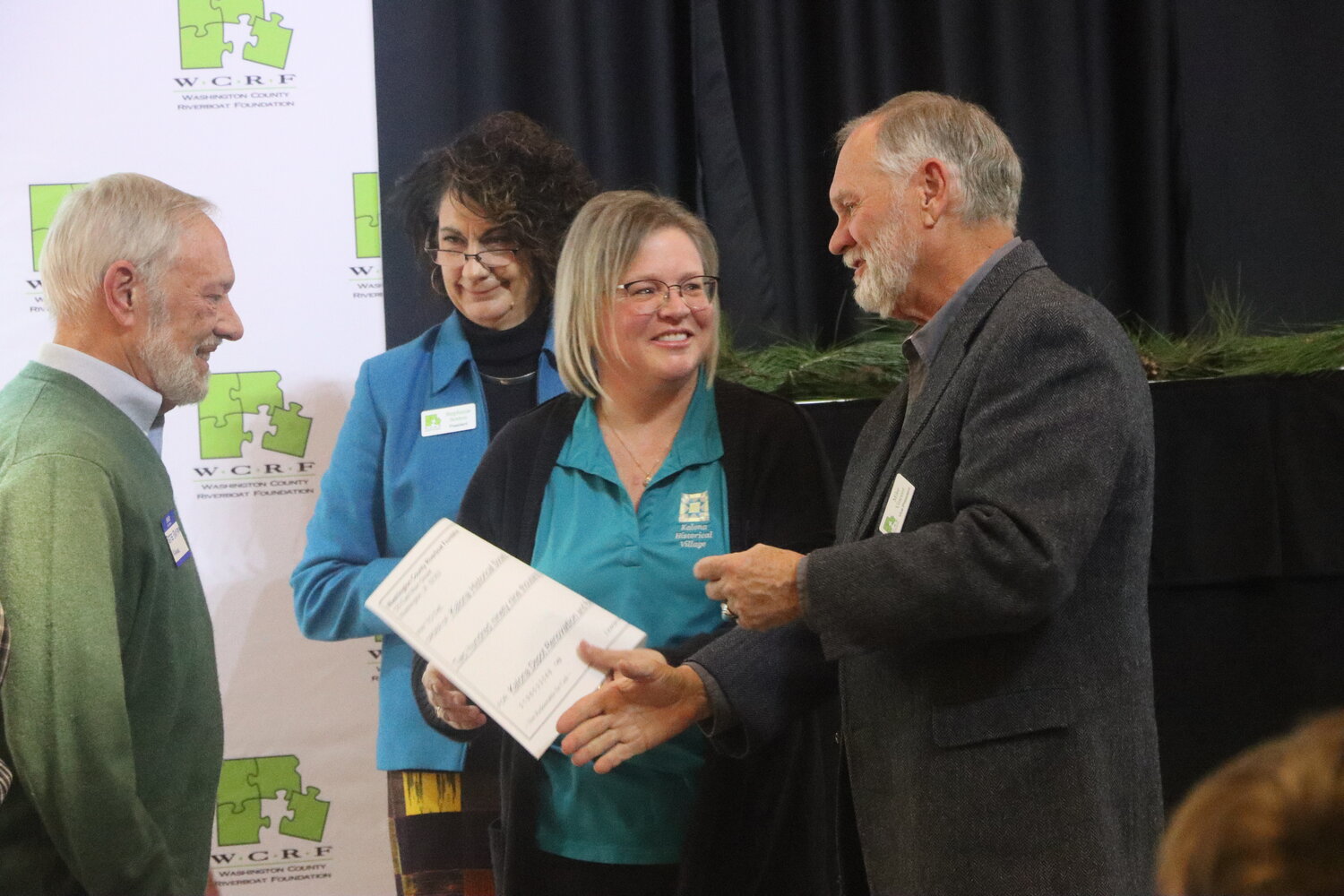 Nancy Roth (center right) receives a giant check from WCRF board vice president Mike Vincent during the awards presentation on Nov. 29.